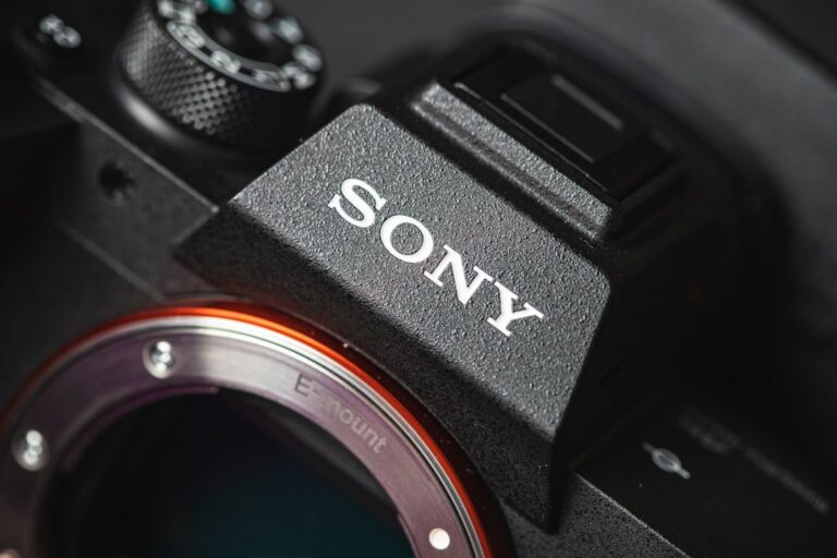 The illuminated buttons on a professional mirrorless camera, glowing in a dark environment for ease of use.