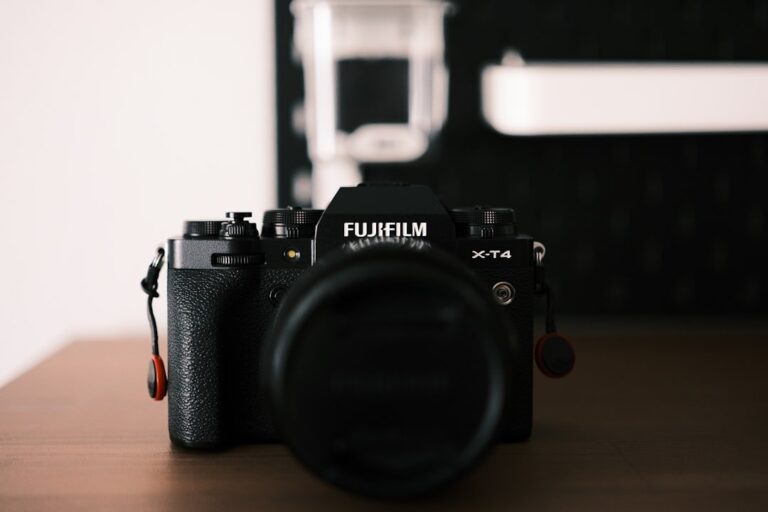 A close-up product shot of the new Fujifilm X-T6 camera body, showing its top dials and lens mount.