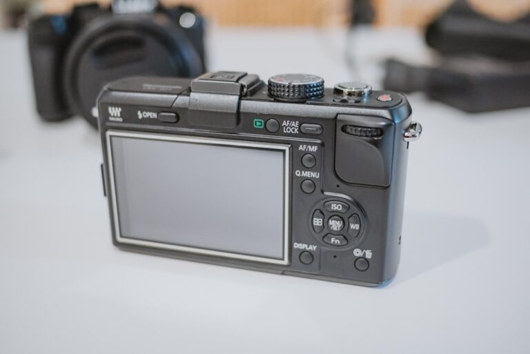 A close-up shot of the Panasonic L10 camera, highlighting its manual control dials and Leica lens.