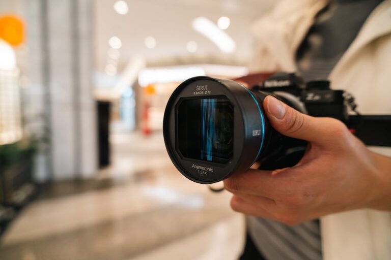 A close-up detail shot of a modern telephoto lens, highlighting the focus ring and lens mount.