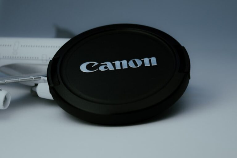 A close-up conceptual image of a high-end Canon RF L-series lens, focusing on the red ring and glass elements.